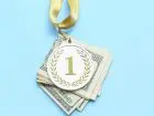 Podatek od nagrody w pracy - medal położony na banknotach na niebieskim tle