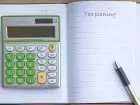 Progi podatkowe - kalkulator w zeszycie i napis tax plaining