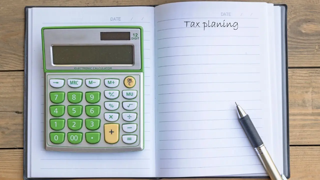 Progi podatkowe - kalkulator w zeszycie i napis tax plaining