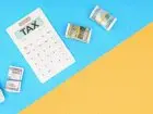 Estoński CIT - napis tax na kalkulatorze, obok banknoty pieniędzy