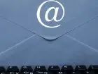 Afera mailowa - koperta, znaczek e-mail i klawiatura komputera