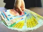 Kobieta trzymająca banknoty euro w dłoni