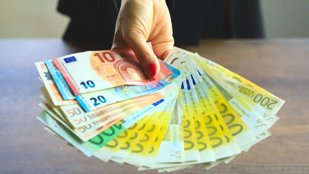 Kobieta trzymająca banknoty euro w dłoni