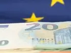 Płaca minimalna w Polsce i Europie - waluta euro na tle flagi UE