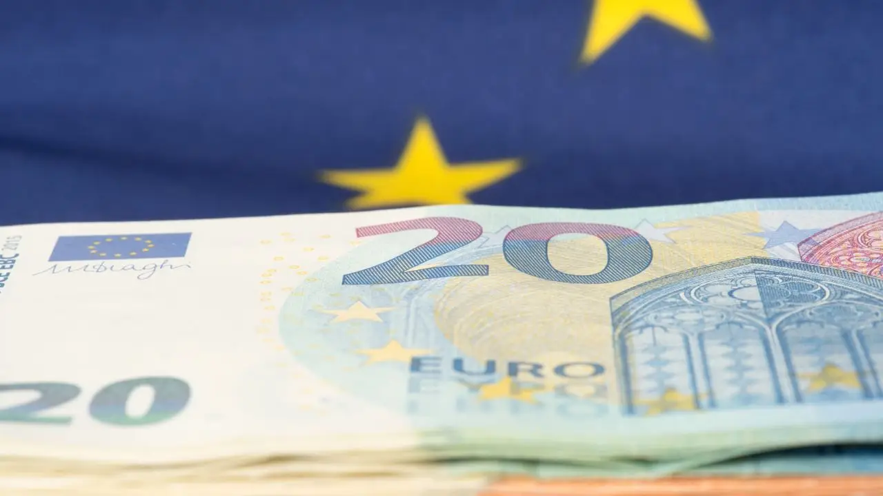 Płaca minimalna w Polsce i Europie - waluta euro na tle flagi UE