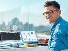 Zarobki freelancerów - freelancer podczas pracy przy laptopie na dworze