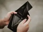 Upadłość konsumencka - pusty portfel trzymany przez mężczyznę w dłoniach