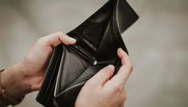 Upadłość konsumencka - pusty portfel trzymany przez mężczyznę w dłoniach
