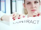 Wypowiedzenie umowy agencyjnej - kobieta rozdzierająca dokument z napisem contract