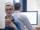 Pracownicy w biurze, zbliżenie na kobietę używającą telefonu