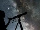 Astronom patrzący w gwieździste niebo przez teleskop