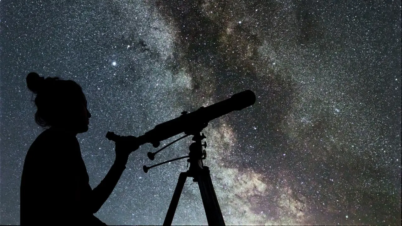 Astronom patrzący w gwieździste niebo przez teleskop
