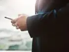 Jak zostać posłem - mężczyzna w garniturze z telefonem w dłoniach