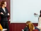 Praca nauczyciela w porze nocnej - nauczyciel przy tablicy z dziećmi