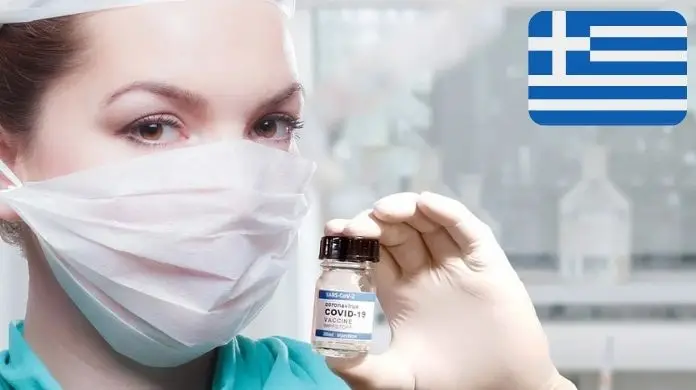 Grecja obowiązkowe testy dla niezaszczepionych pracowników - pielęgniarka trzymająca szczepionkę