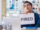 Likwidacja stanowiska pracy - mężczyzna przy biurku z kartką fired