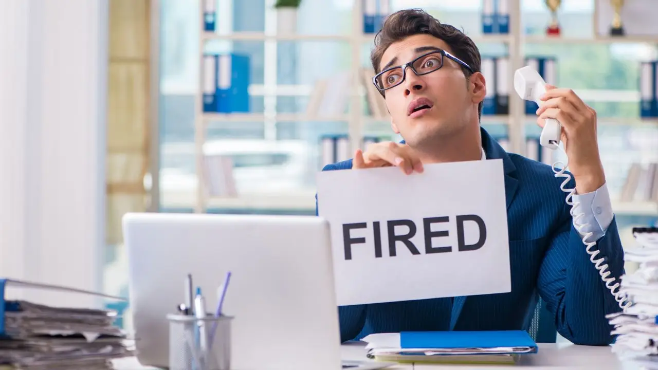 Likwidacja stanowiska pracy - mężczyzna przy biurku z kartką fired