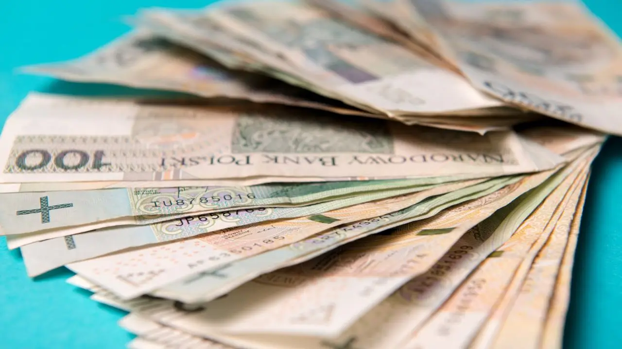 Płaca minimalna 2025 - pieniadze banknoty polskie na niebieskim tle