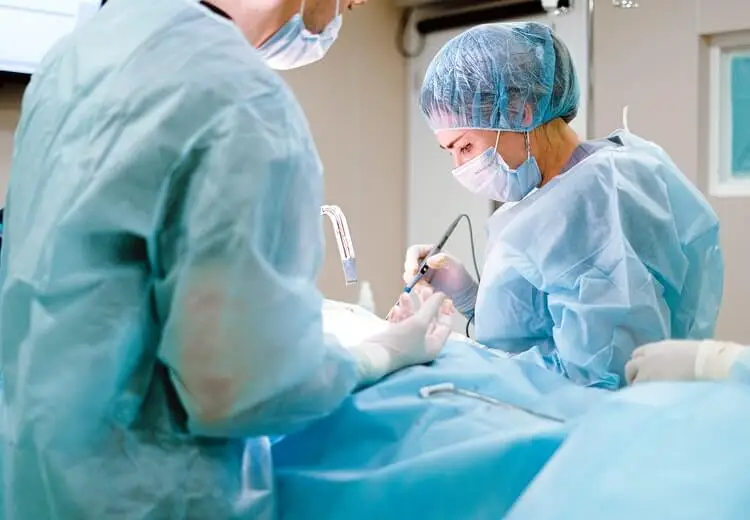 przeprowadzająca operację kobieta, która ukończyła specjalizację chirurga plastycznego