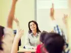 Zmiany dla nauczycieli - nauczycielka za biurkiem w sali z dziećmi