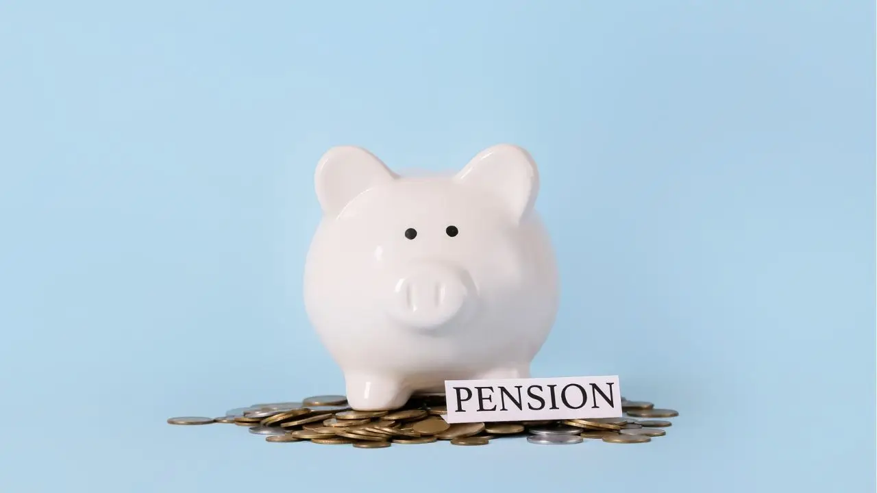 Napis pension, skarbonka świnka i monety na niebieskim tle