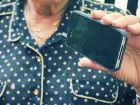 Oszustwo na czternastkę - emerytka trzymająca telefon w dloni