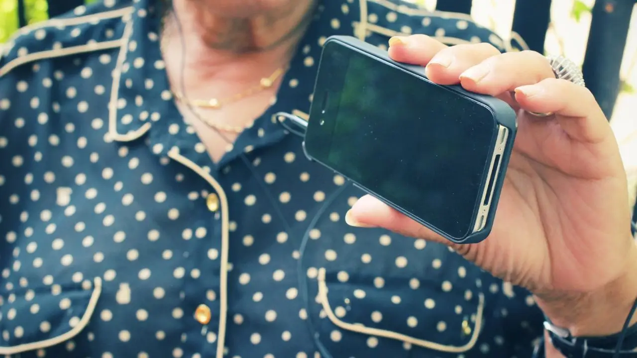 Oszustwo na czternastkę - emerytka trzymająca telefon w dloni