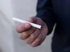Przerwa na papierosa - zbliżenie na męską dłoń trzymającą papierosa