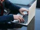 Wyrejestrowanie z urzędu pracy - mężczyzna korzystający z laptopa na świeżym powietrzu