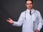 Lekarz w fartuchu unoszący dłoń do góry