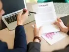 Okres wypowiedzenia - osoba pokazująca długopisem zapis w umowie