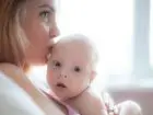 Wniosek o urlop macierzyński - kobieta całująca swoje dziecko w głowę