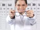 Optyk w pracy w salonie, pokazuje okulary