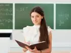 CV i list motywacyjny nauczyciela - kobieta nauczyciel na tle tablicy w sali lekcyjnej