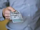 Mężczyzna trzymający banknoty w dłoni