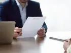 List motywacyjny na praktyki - meżczyzna czytajacy dokument przekazany mu przez kandydata