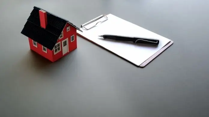 Wypowiedzenie umowy najmu - długopis na dokumencie i figurka domu