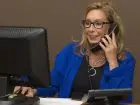 Rejestratorka medyczna - kobieta przy komputerze rozmawiająca przez telefon