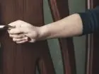Akwizytor- zbliżenie na dłoń na klamce w trakcie otwierania drzwi