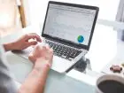 Analityk analizujący dane z wykresów na ekranie laptopa