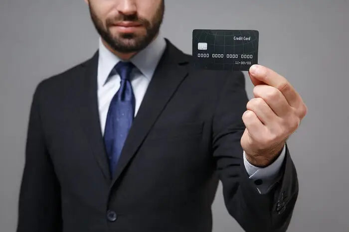 Cashback - biznesmen trzymający kartę bankomatową