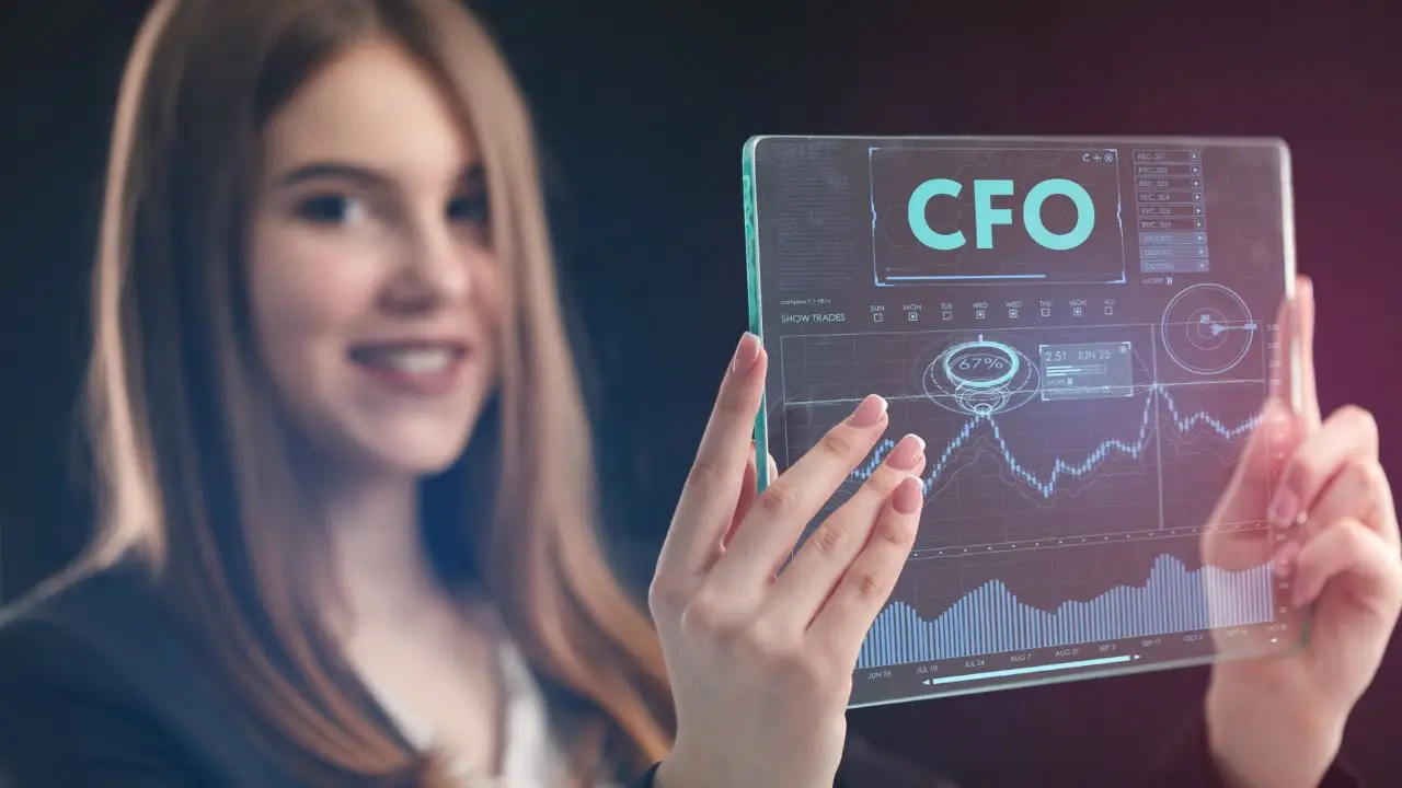 Uśmiechnieta kobieta trzmajaca ekran z wykresami i napisem CFO