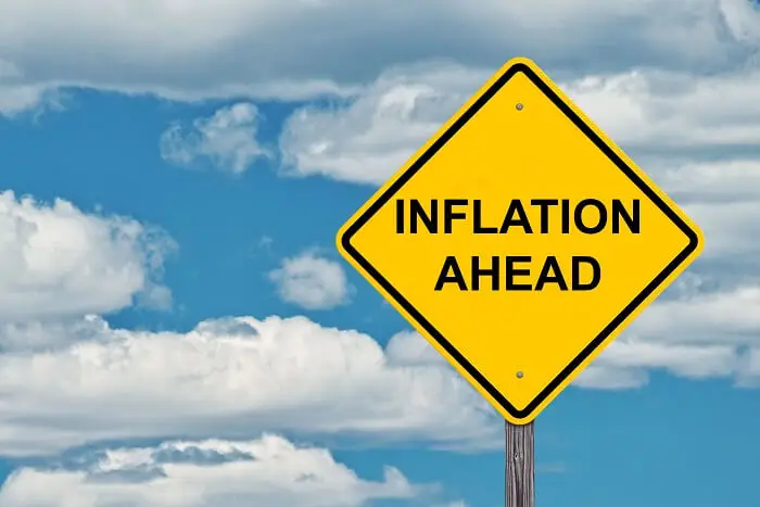 Inflacja luty 2022 - znak drogowy z napisem inflation ahead na tle nieba