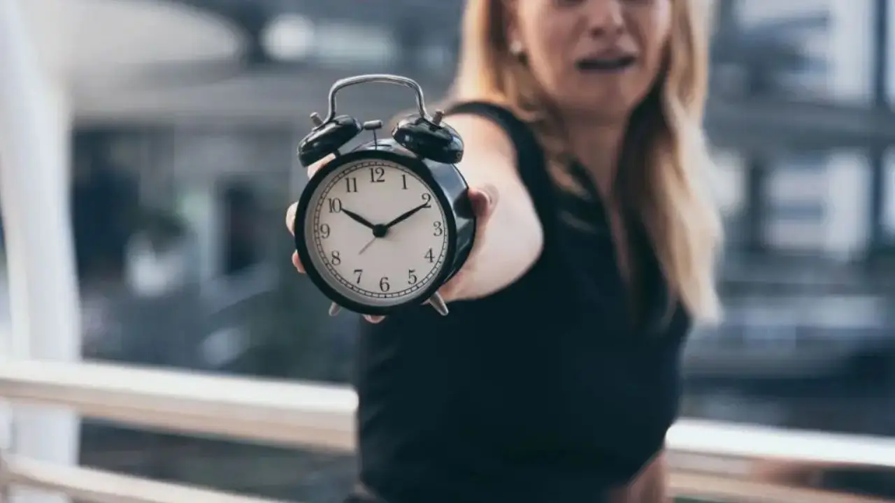 Wymiar czasu pracy 2025 - kobieta z zegarem w dłoni
