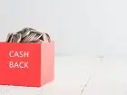 Cashback - napis na czerwonym pojemniku z monetami