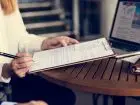 Cover letter - kobieta pisząca dokument przy stole