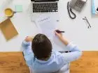 Krótki list motywacyjny - osoba przy biurku coś pisząca