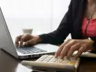 Key account manager - kobieta pracujaca przy laptopie z kalkulatorem
