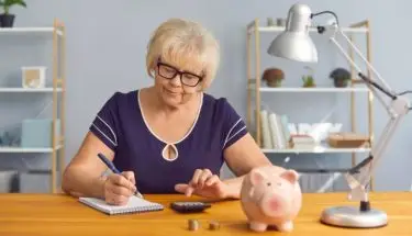 Podatek od renty rodzinnej - kobieta dokonująca obliczeń finansowych na kartce