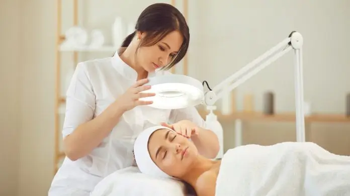 Kosmetologia co robić po studiach - kosmetyczka wykonująca pacjentce zabieg w gabinecie
